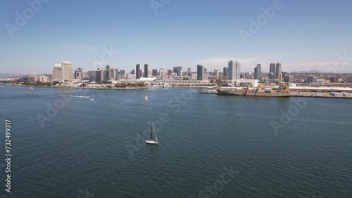 some boats in a large body of water with a city behind it © Wirestock