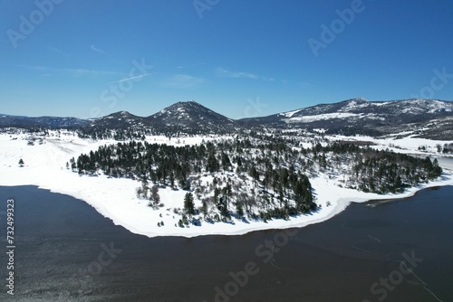 An aerial view of the Lake Cuyamaca between snowy forested lands photo