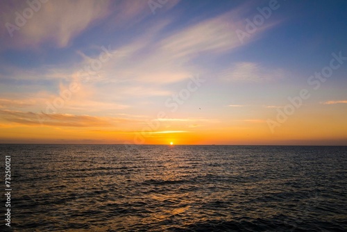 Stunning sunrise over a serene blue ocean with gentle waves rolling to shore