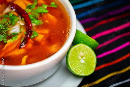 Closeup of a bowl of menudo rojo soup with lime in a Mexican Restaurant photo