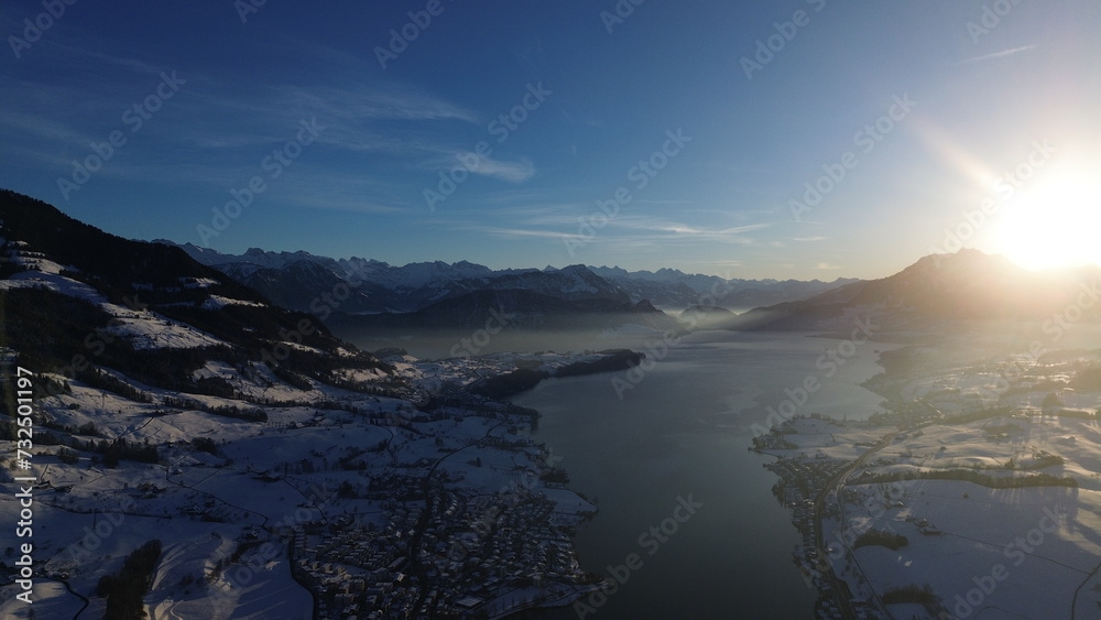 the sun shines on the surrounding mountains and glaciers as seen from the sky the sun shines on the surrounding mountains and glaciers as seen from the sky