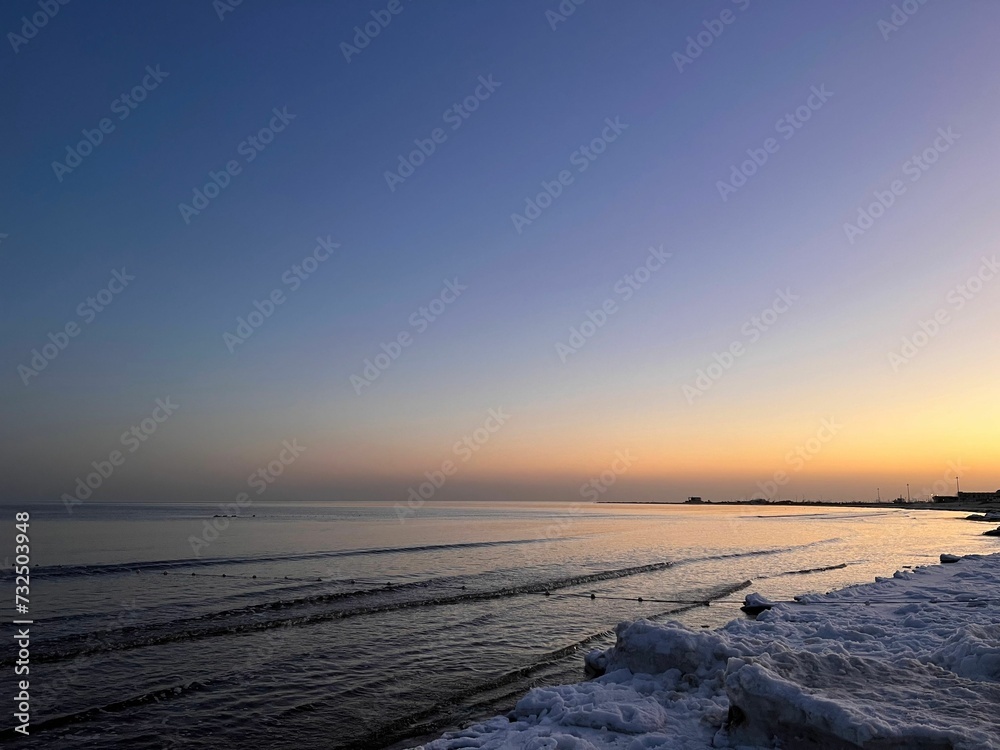 Serene beach scene with a majestic sky and sea at sunset.