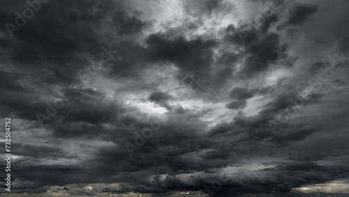 dark dramatic sky with black stormy clouds before rain or snow as abstract background, extreme weather, the sun shines through the clouds, high contrast photo photo
