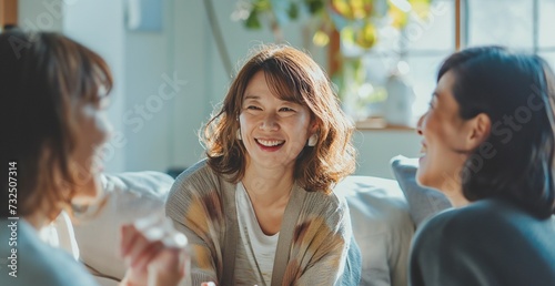 明るいリビングで楽しく会話する日本の中年女性三人組 photo