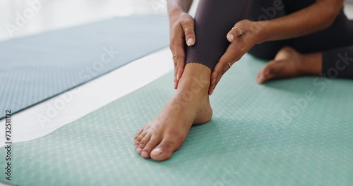 Pain, yoga mat and woman with ankle injury for fitness pilates exercise or workout in gym. Accident, hurt and closeup of female person massaging foot muscle sprain or bruise with medical emergency. photo