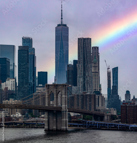 The Brooklyn Bridge with the rainbow linking the boroughs of Manhattan and Brooklyn in New York City  USA   this bridge is one of the most famous and well known in the Big Apple.