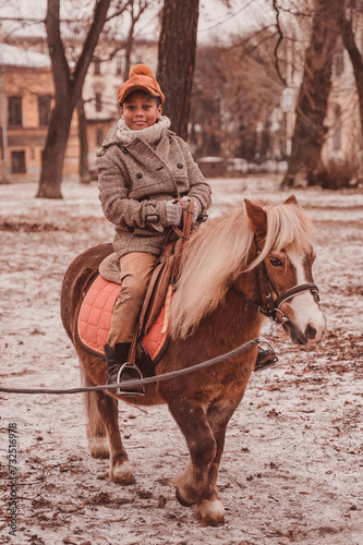boy riding a pony that raises its leg