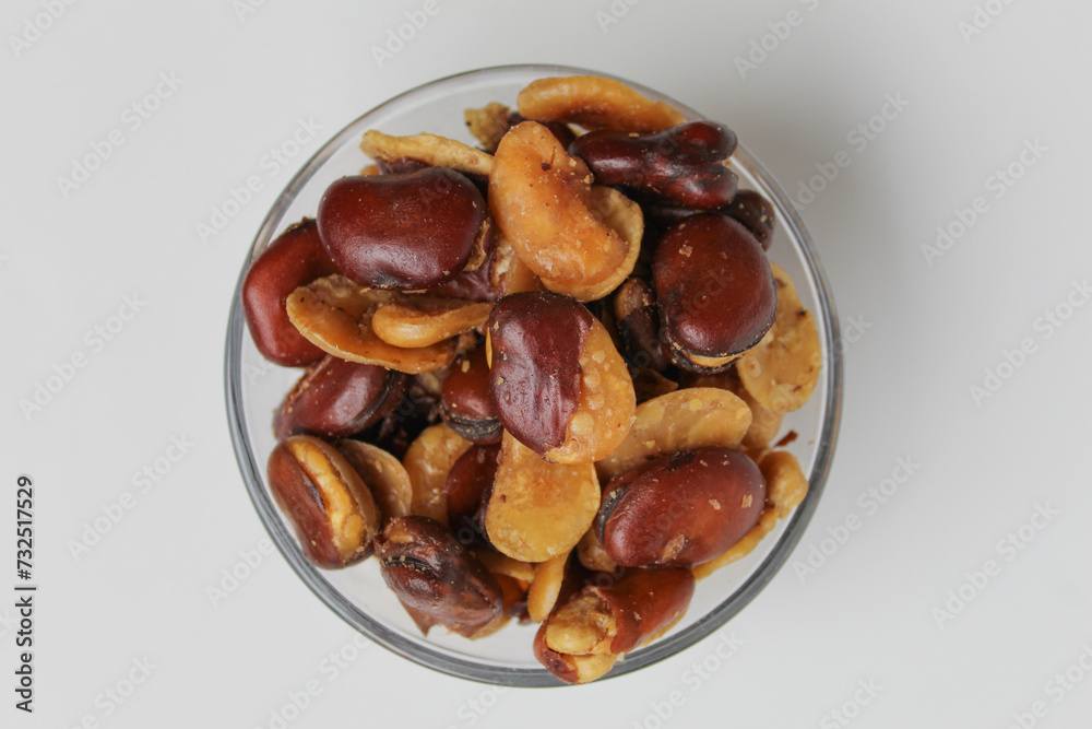 Kacang koro, or cooked jack bean, in a transparent glass bowl, isolated on white background