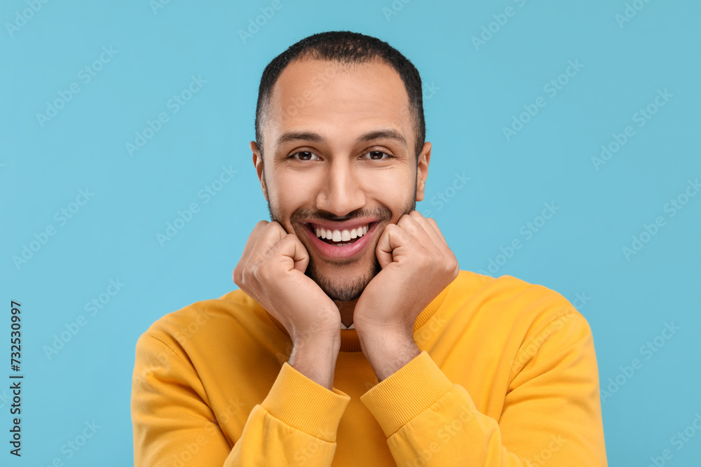 Portrait of smiling man with healthy clean teeth on light blue background Portrait of smiling man with healthy clean teeth on light blue background