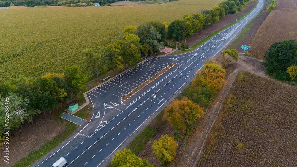 Drone aerial view new asphalt road in autumn on a cloudy day, road markings