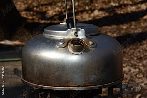 Aluminum kettle, brewing tea in nature.