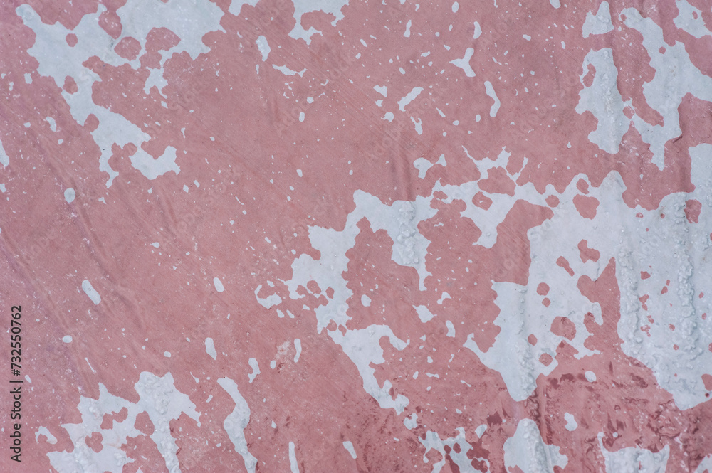 Fototapeta premium Background, texture of wet oilcloth, tarpaulin in ice, with drops of water, snow on a red surface. Close-up photography, top view, abstraction.