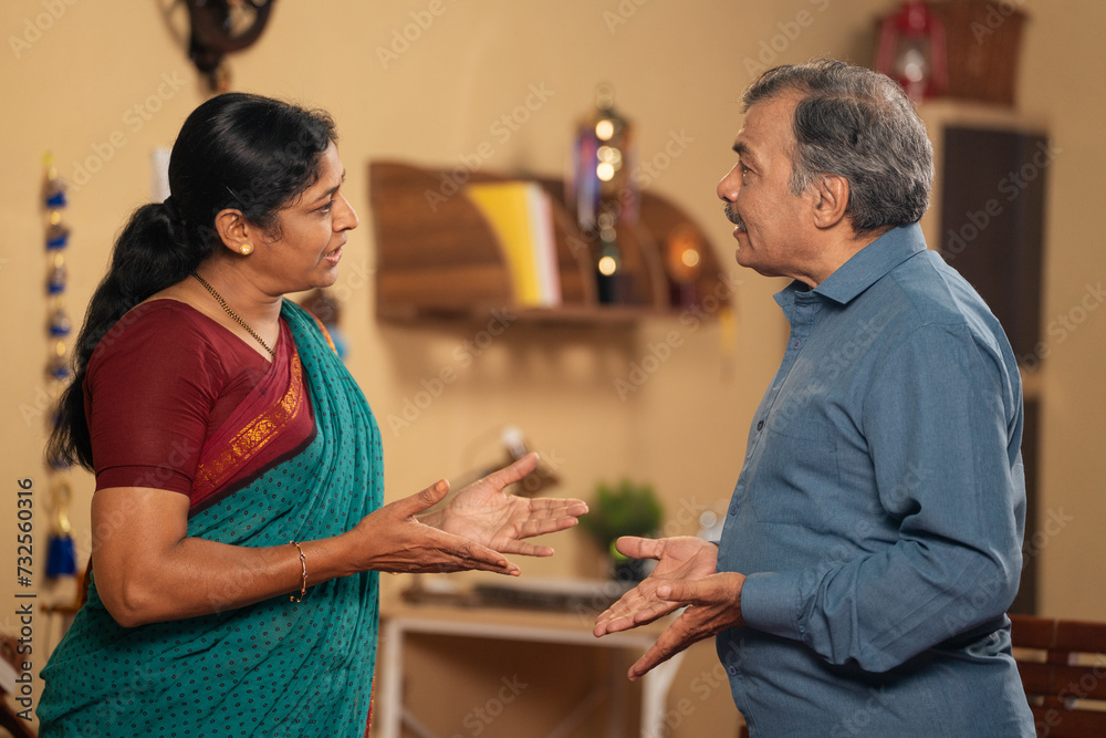 Obraz premium Indian senior married couples arguing each other while talking or during communication at home - concept of Conflict, family problems and misunderstanding