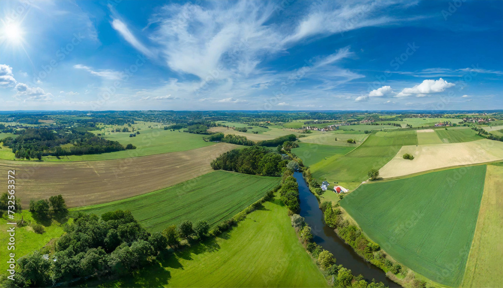 Drone flying over beautiful countryside; aerial view above a country landscape during a clear summer day.