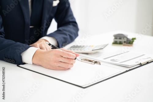 不動産価格を査定するビジネスマンの手元 photo