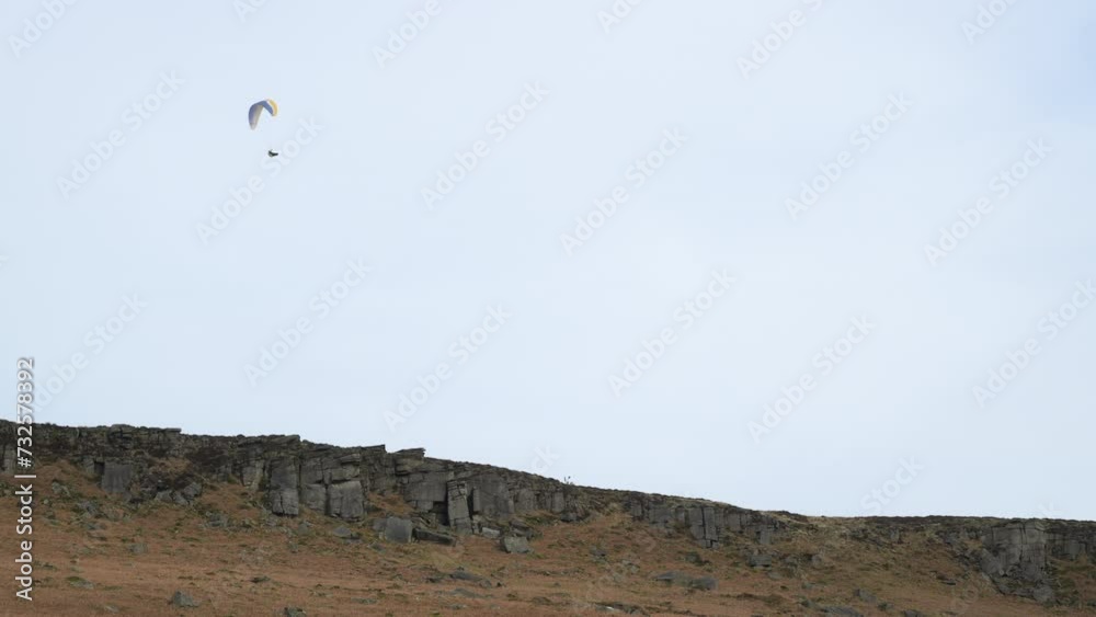 A single paraglider at Stanage Edge in the Derbyshire Peak District during winter. A single paraglider at Stanage Edge in the Derbyshire Peak District during winter.