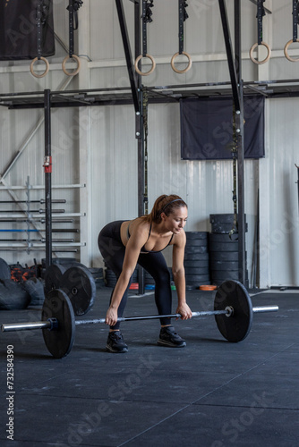 Woman lifting weight in the industrial gym