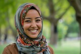 Close up Muslim woman smilling at camera near trees in the park