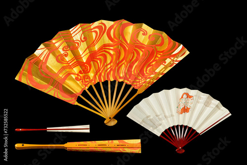Japanese traditional hand fans from paper and bamboo with gold and red ornament, isolated on black