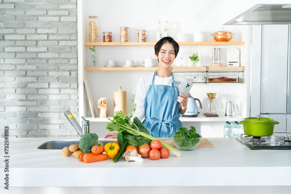 キッチンに立つ笑顔の若い女性