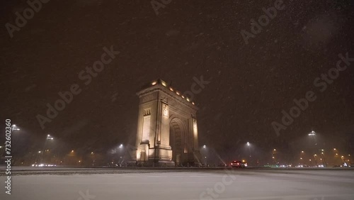 Bucharest night snowfall full HD slow motion video 100fps. Amazing video with massive snow falling from sky during the night. View to Arch of Triumph landmark building. photo