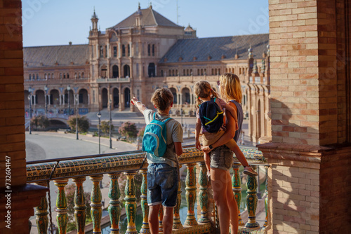 Tourists with kids admire famous square of Spain in Seville photo