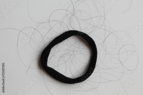 Fotografija A black hair ties with strands of black hair