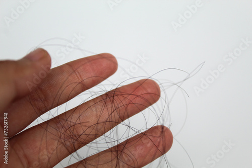 Strands of black hair on the palm of female hand. Hair loss or hair falling out or hair breakage photo