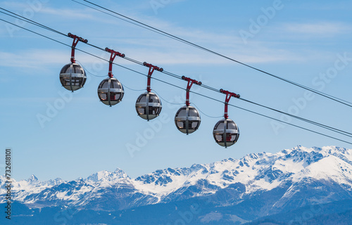 Gondola bubbles against the blue sky and the French Alps in the background. Cable car taking tourists to Fort de La Bastille in Grenoble, France photo