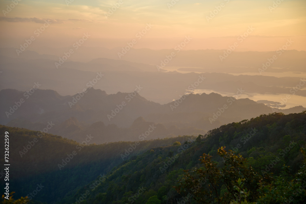 Capture the essence of adventure and tranquility in a striking landscape photo showcasing a camping setup amidst the majestic mountain ranges of Khao San Nok Wua and Pom Pee  , Thailand. 