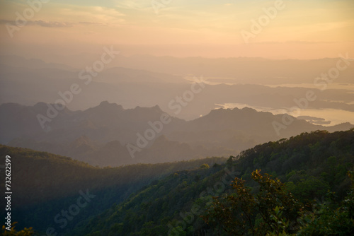 Capture the essence of adventure and tranquility in a striking landscape photo showcasing a camping setup amidst the majestic mountain ranges of Khao San Nok Wua and Pom Pee , Thailand. 