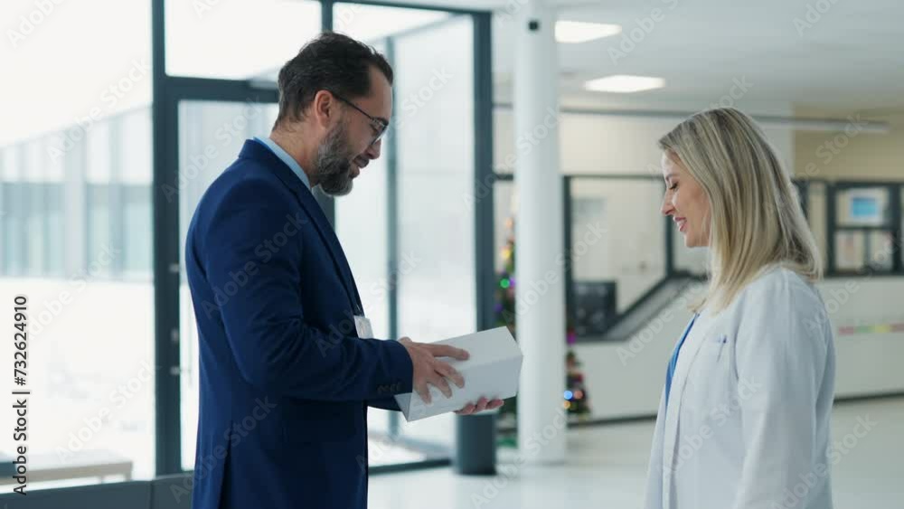 Pharmaceutical sales representative talking with doctor in medical building. Ambitious male sales representative presenting new medication on tablet.