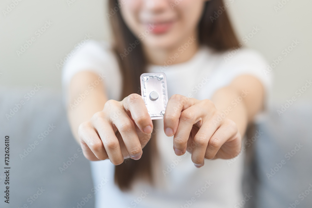 Emergency contraception and pregnancy concept asian young woman hand holding birth control pills, hormonal oral contraceptive medicine at home, take pharmaceutical to prevention virus sex disease. Emergency contraception and pregnancy concept asian young woman hand holding birth control pills, hormonal oral contraceptive medicine at home, take pharmaceutical to prevention virus sex disease.