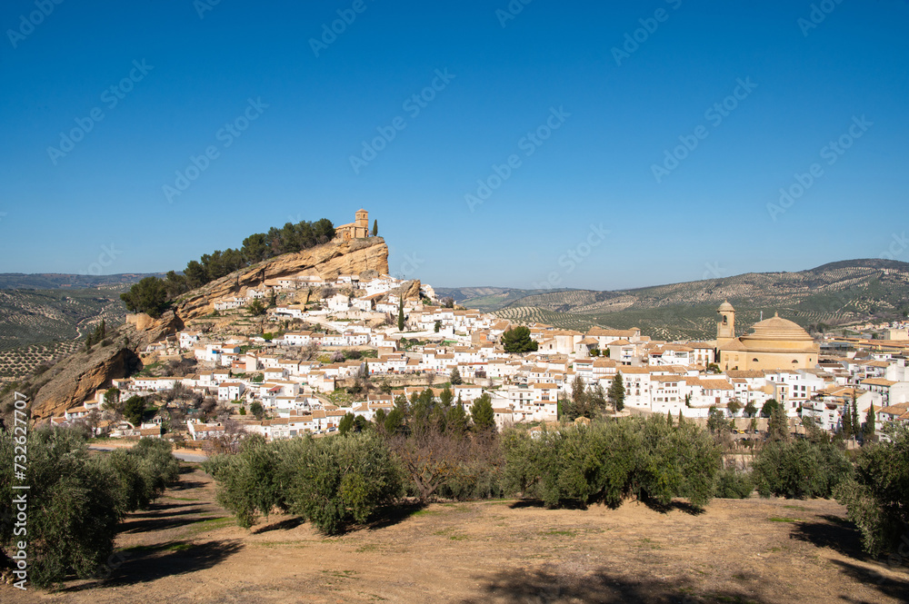 Old town Montefrio. The ruins of a Moorish castle on a rock and white houses under cloudless sky. Pueblos blancos, Andalusia, Spain.