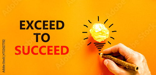 Exceed to succeed symbol. Concept words Exceed to succeed on beautiful orange paper. Beautiful orange background. Light bulb icon. Businessman hand. Business and exceed to succeed concept. Copy space. photo