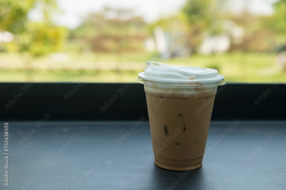 Ice cappuccino coffee on table with spring garden view of outdoor cafe Ice cappuccino coffee on table with spring garden view of outdoor cafe