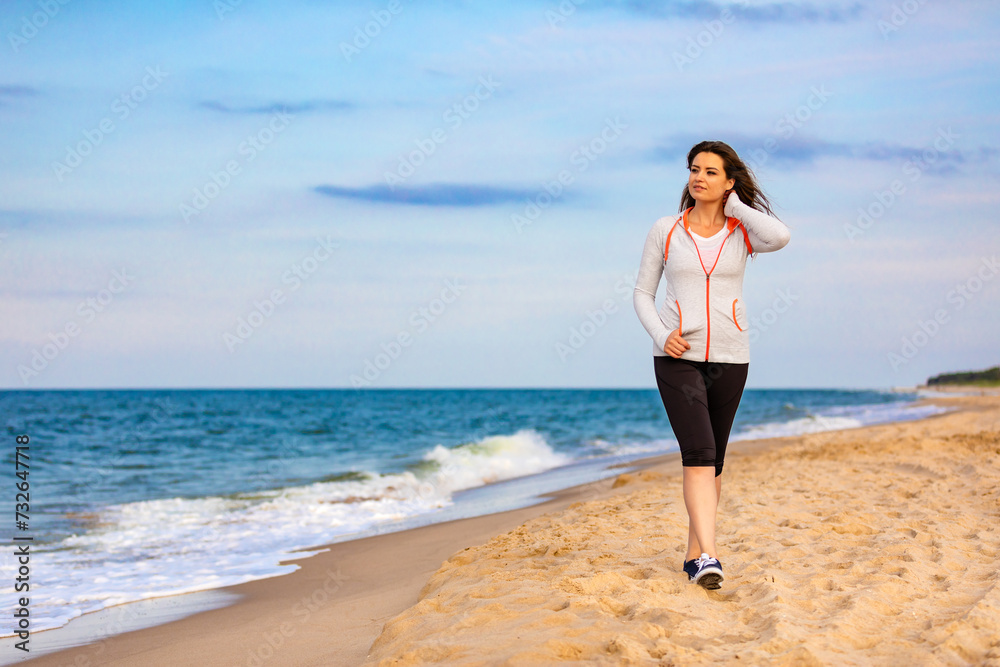 Beautiful mid adult woman walking on beach
