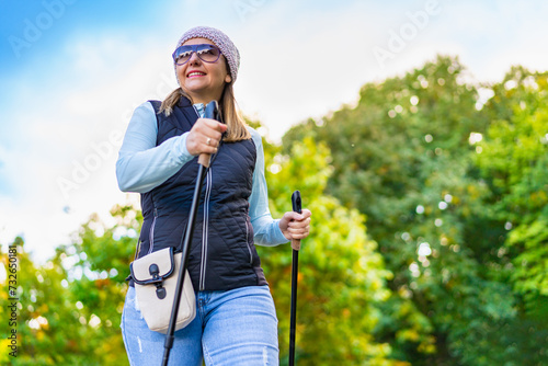 Nordic walking -  mid-adult woman exercising in city park

