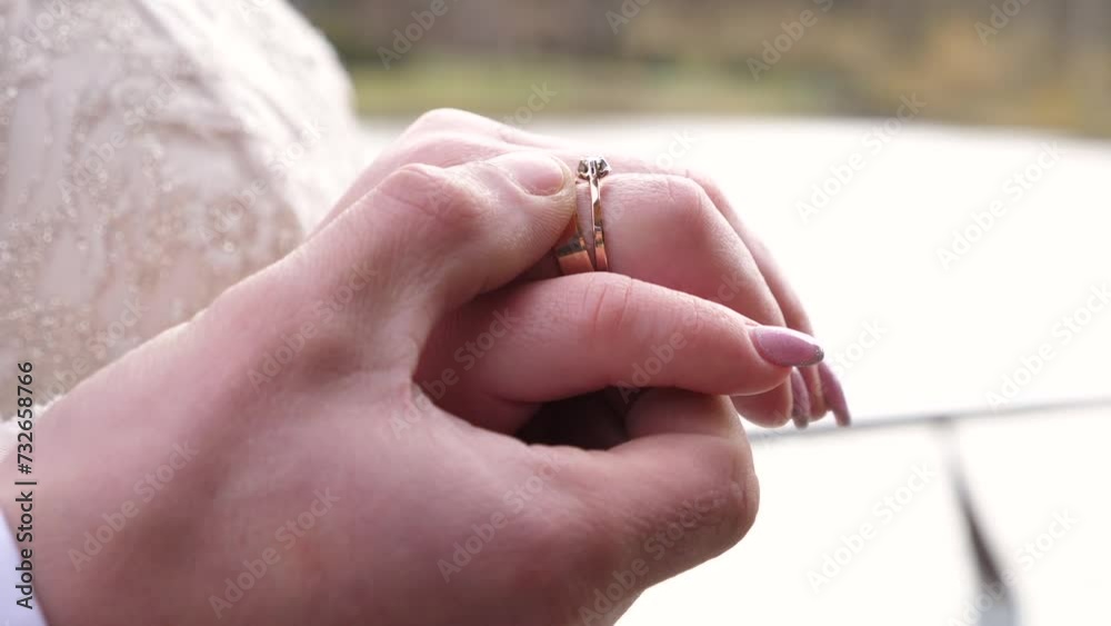 The groom gently touches the wedding ring on the bride's hand. Love and emotions. The groom gently touches the wedding ring on the bride's hand. Love and emotions.