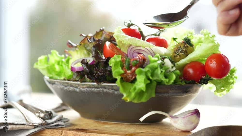 Colorful salad with fresh ingredients prepared with a spoon of olive oil in a ceramic bowl. Healthy nutrion concept for fitness and spring diet.  Video mp4 file.