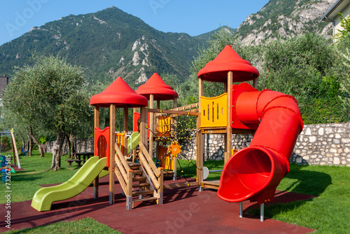 Parco giochi per bambini con scivolo e casette di legno photo