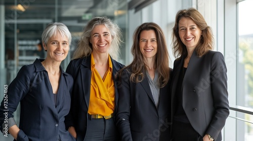 A group of smiling middle-aged businesswomen in the office, a joint corporate photo of successful international women from around the world.