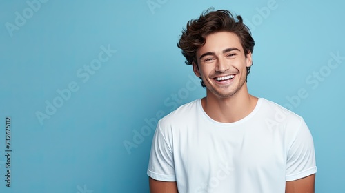 Dental banner. Young man with beautiful smile on blue background. Teeth whitening. Happy man