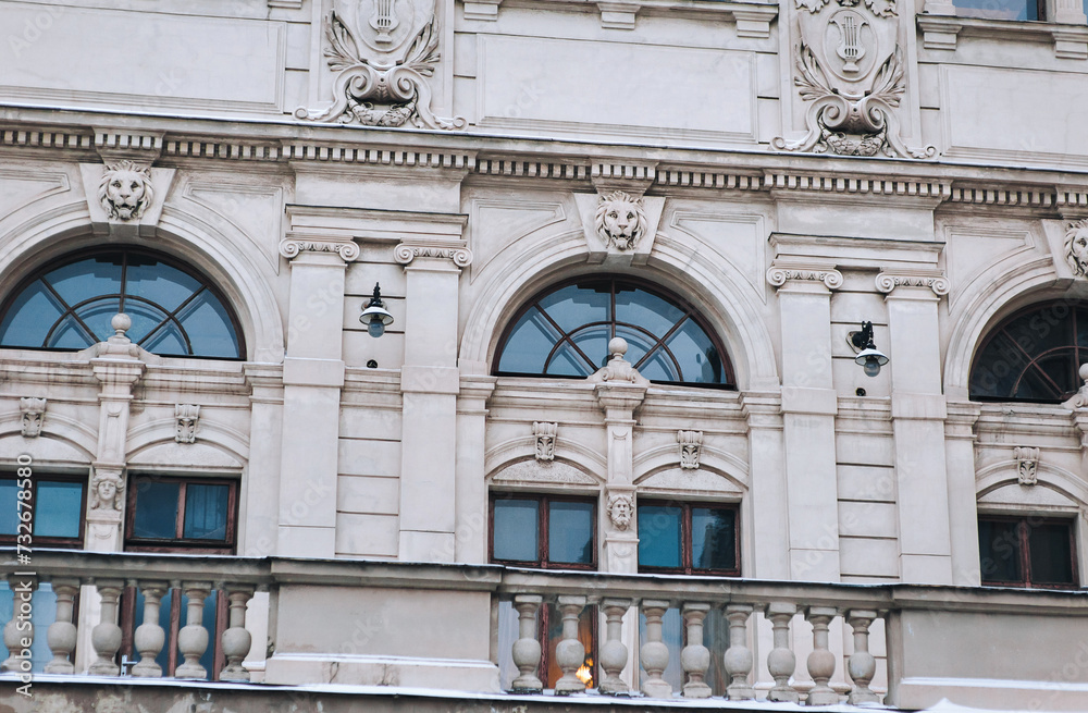 Facade of the old classical building of the Opera and Ballet Theater in Lviv, Ukraine. Pilasters, capitals, stucco and a window with a mascaron. Relief and decorative elements of architecture.