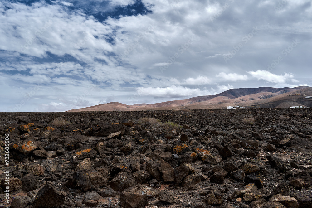 Arid land with mountains and clouds on sky in Betancuria, Fuerteventura, Spain