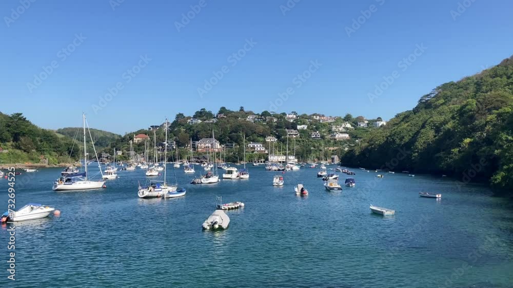 Multiple sailing boats anchored on the River Yealm, looking towards Newton Ferrers and Noss Mayo. A stunning location in the scenic South Hams of Devon, taken in summer - UK Multiple sailing boats anchored on the River Yealm, looking towards Newton Ferrers and Noss Mayo. A stunning location in the scenic South Hams of Devon, taken in summer - UK