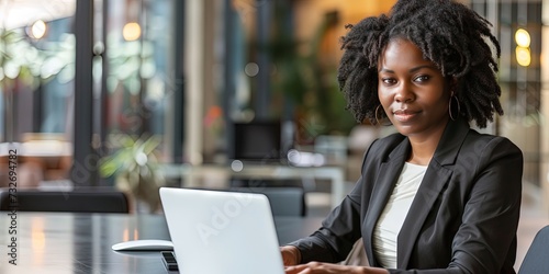 Black Woman business executive working on laptop computer in a modern office