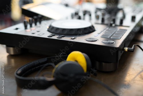 stylish yellow DJ headphones near the controller on the table