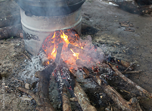 Cooking using reclaimed wood as an ancient fuel.