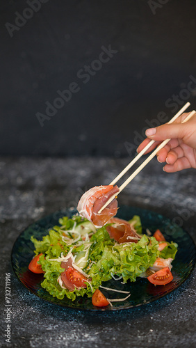 Seafood salad served on a beautiful plate. Salad with king prawns and prosciutto.